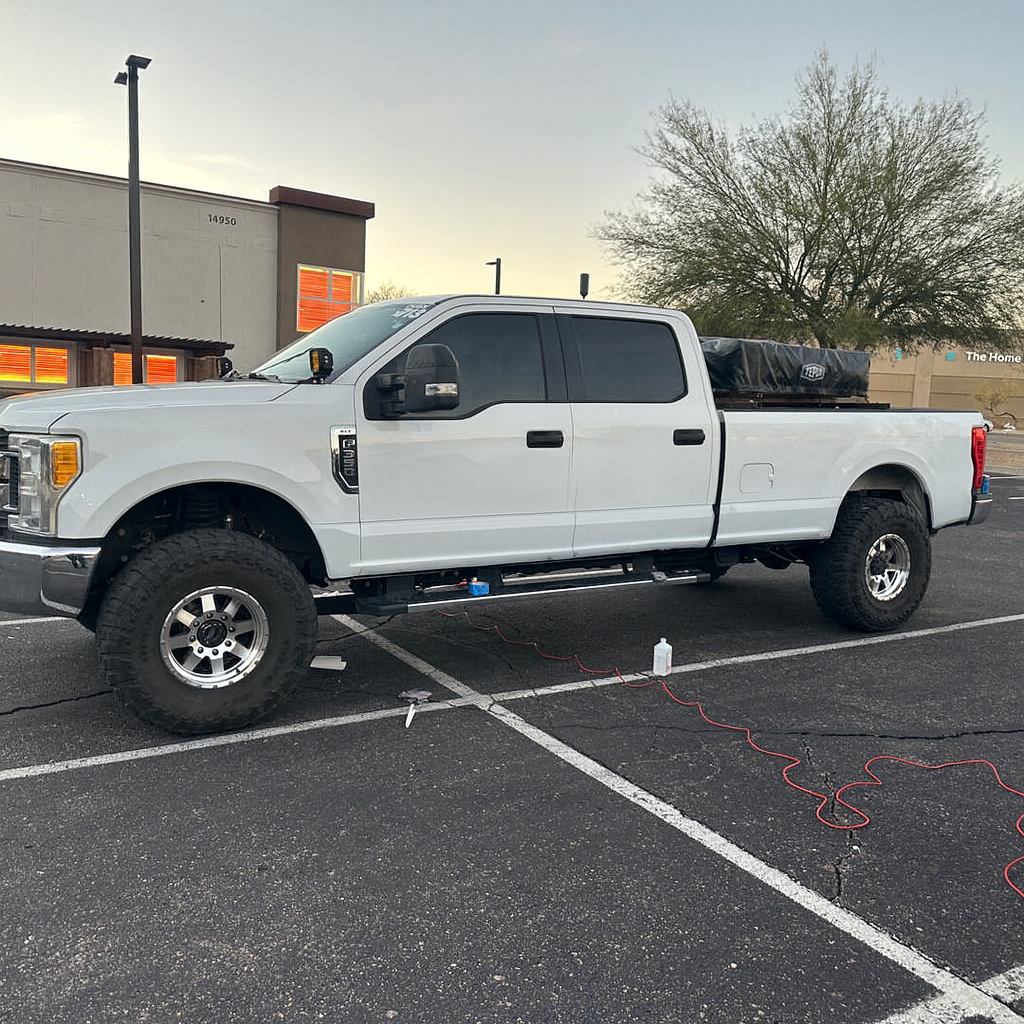 White pickup truck parked in a parking lot with a building and tree in the background. decalwolf decal wolf arizona mesa